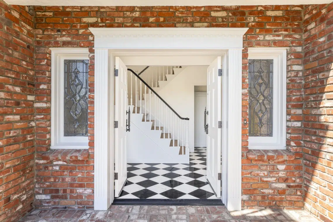 Brick entrance with open doors leading to a staircase in Pacific Palisades - Open Air Homes.