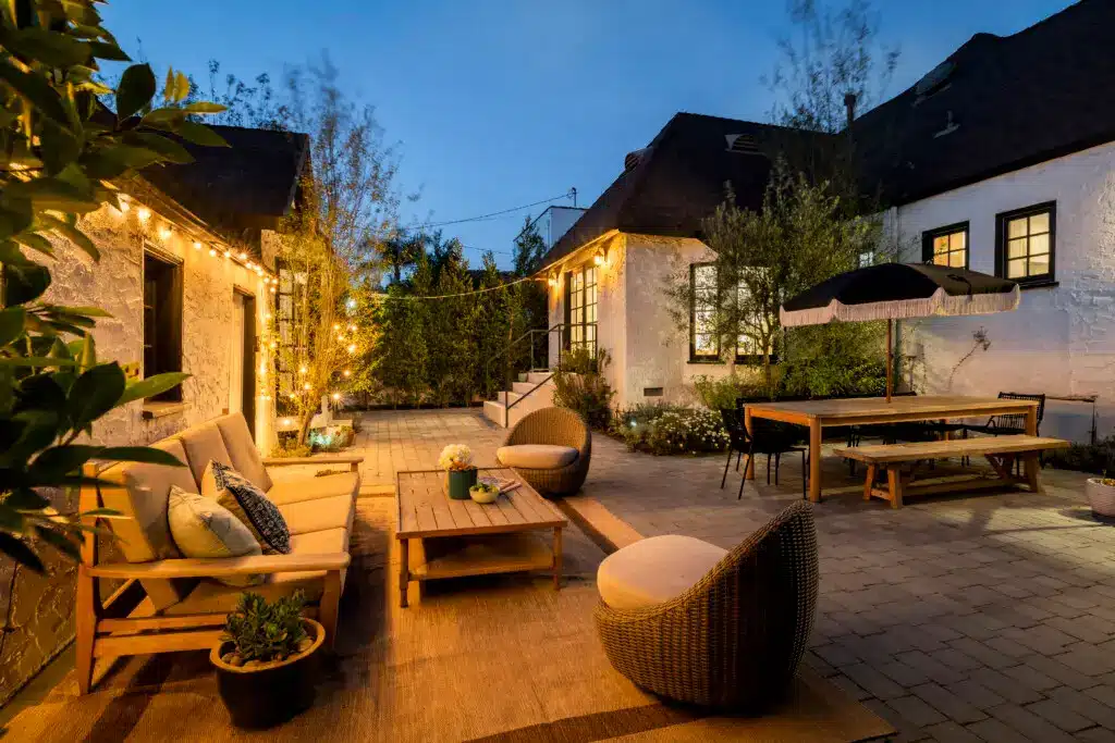 Comprehensive Guide for 5-Star STR Reviews 9 Comprehensive Guide to Securing 5-Star Guest Reviews - Outdoor patio with wooden coffee table, seating area, and dining area with warm lighting in a Beverly Grove rental.