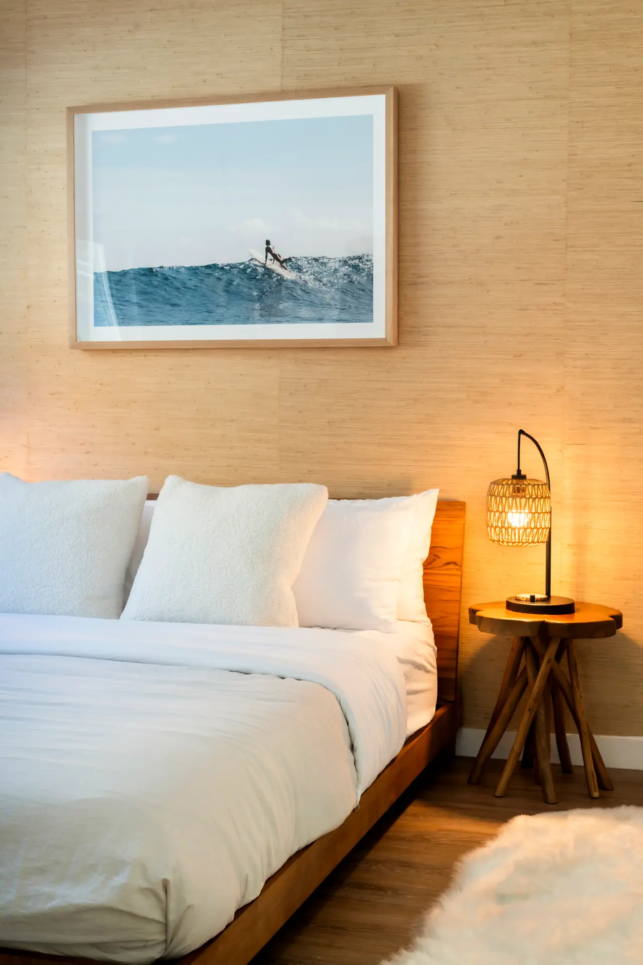 Modern bedroom with a comfortable bed, bedside table, and surfer artwork – Open Air Homes