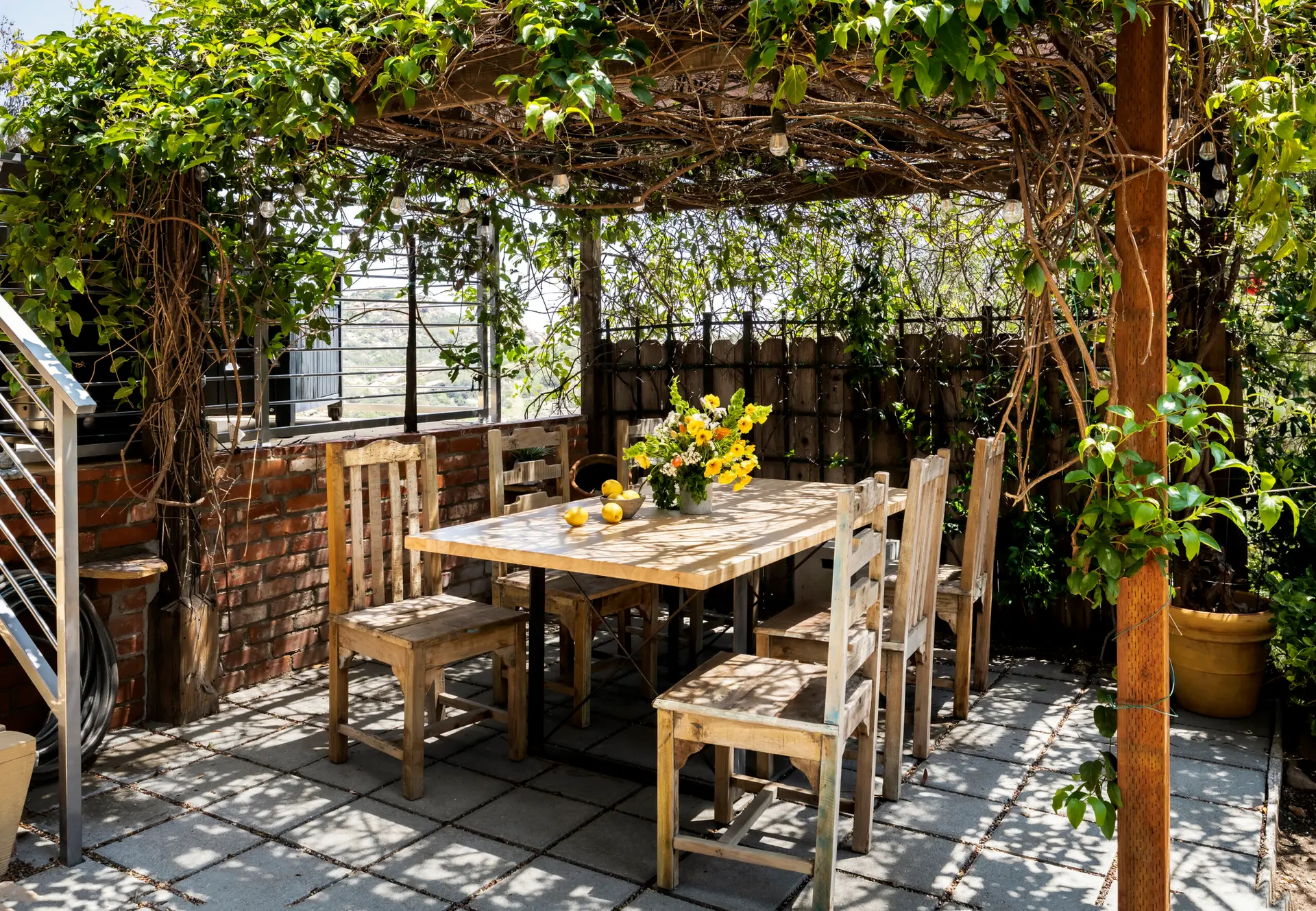 Encino Airbnb Management - Outdoor dining area with wooden table and chairs under pergola at Retreat to the Rocks, Studio Road, Ventura County