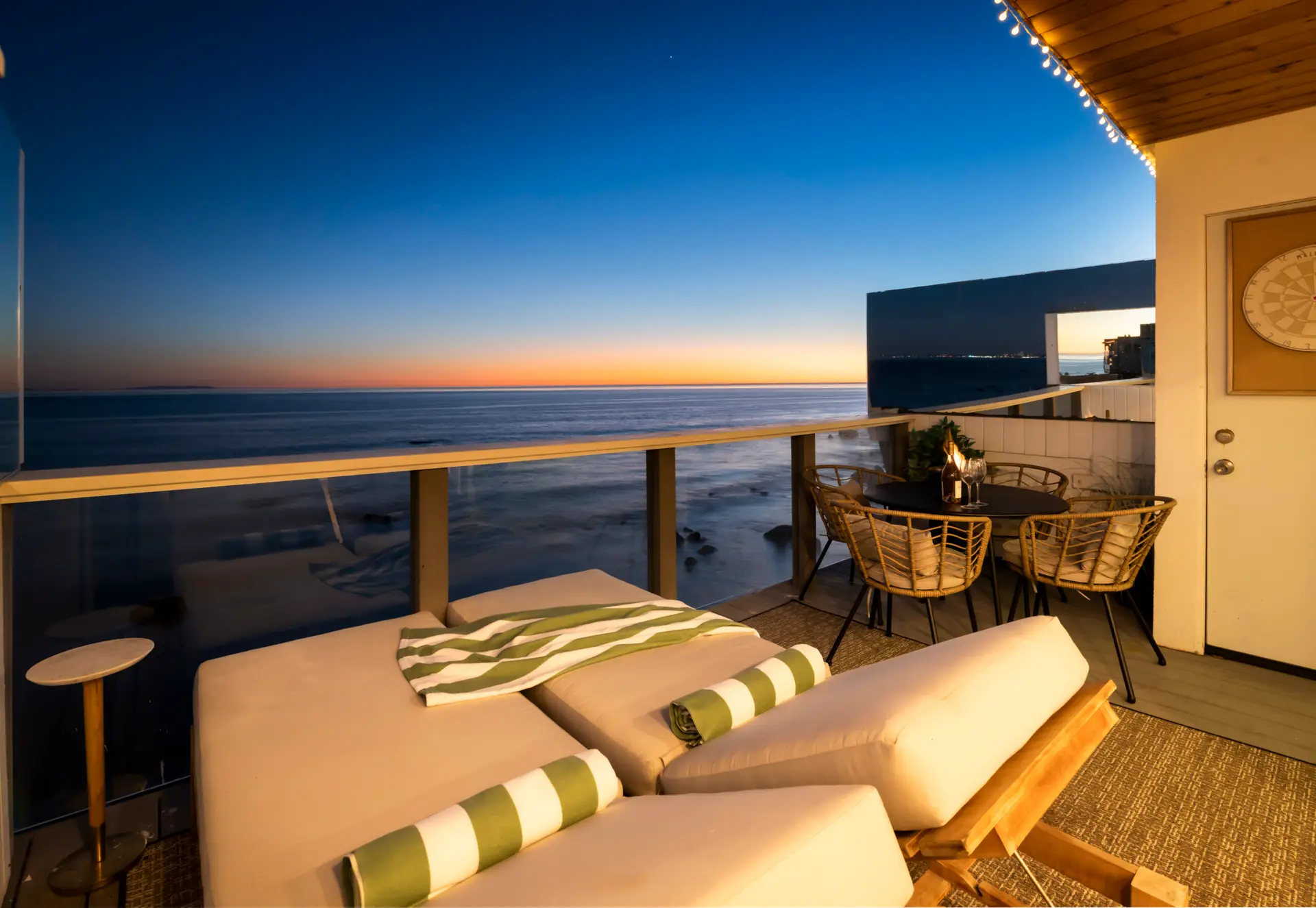 Balcony with lounge chairs and ocean view at sunset – Open Air Homes