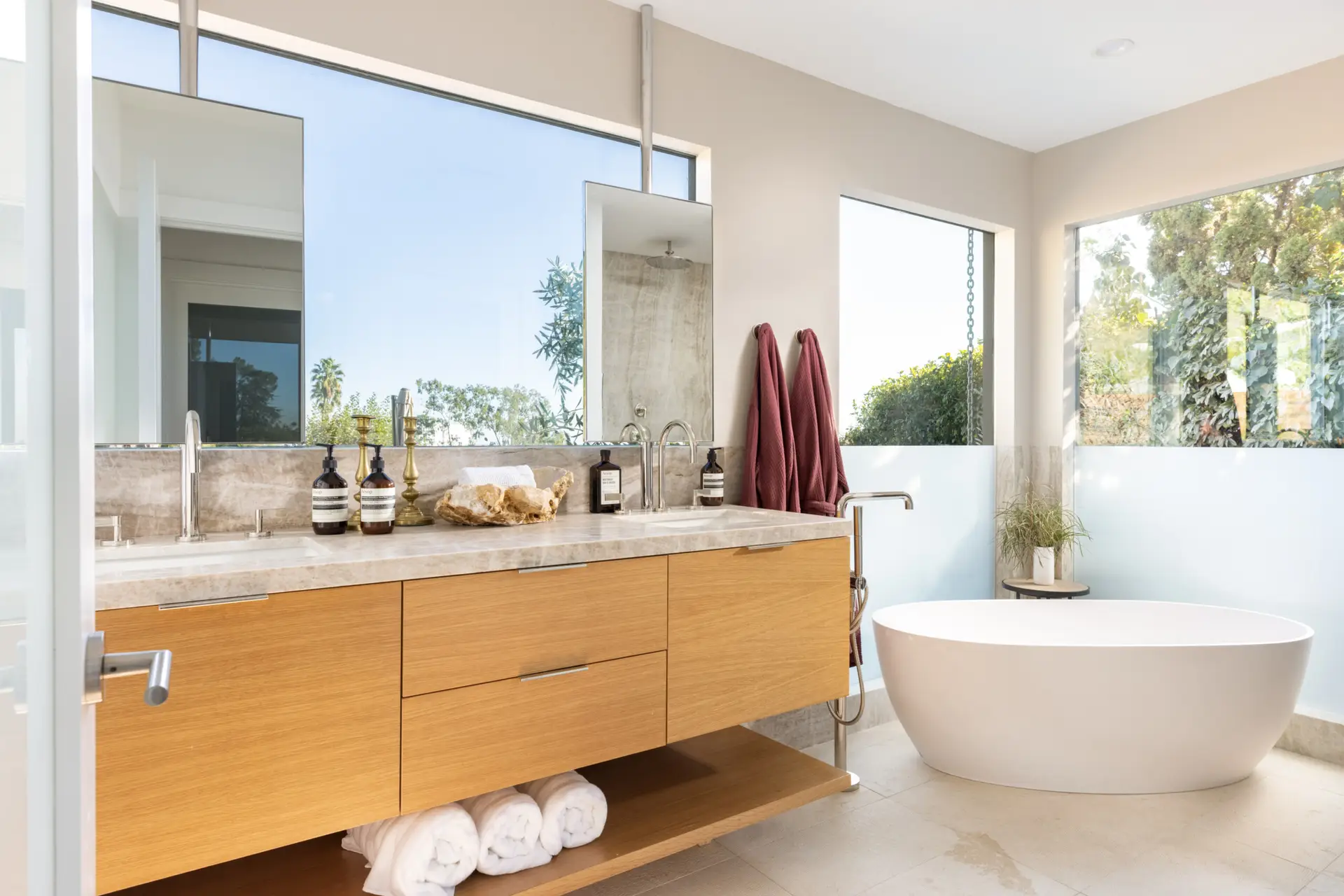 Highland Park Airbnb Management - Bathroom with wooden vanity, large mirror, and freestanding bathtub at Hollywood Hills Home - Open Air Homes.