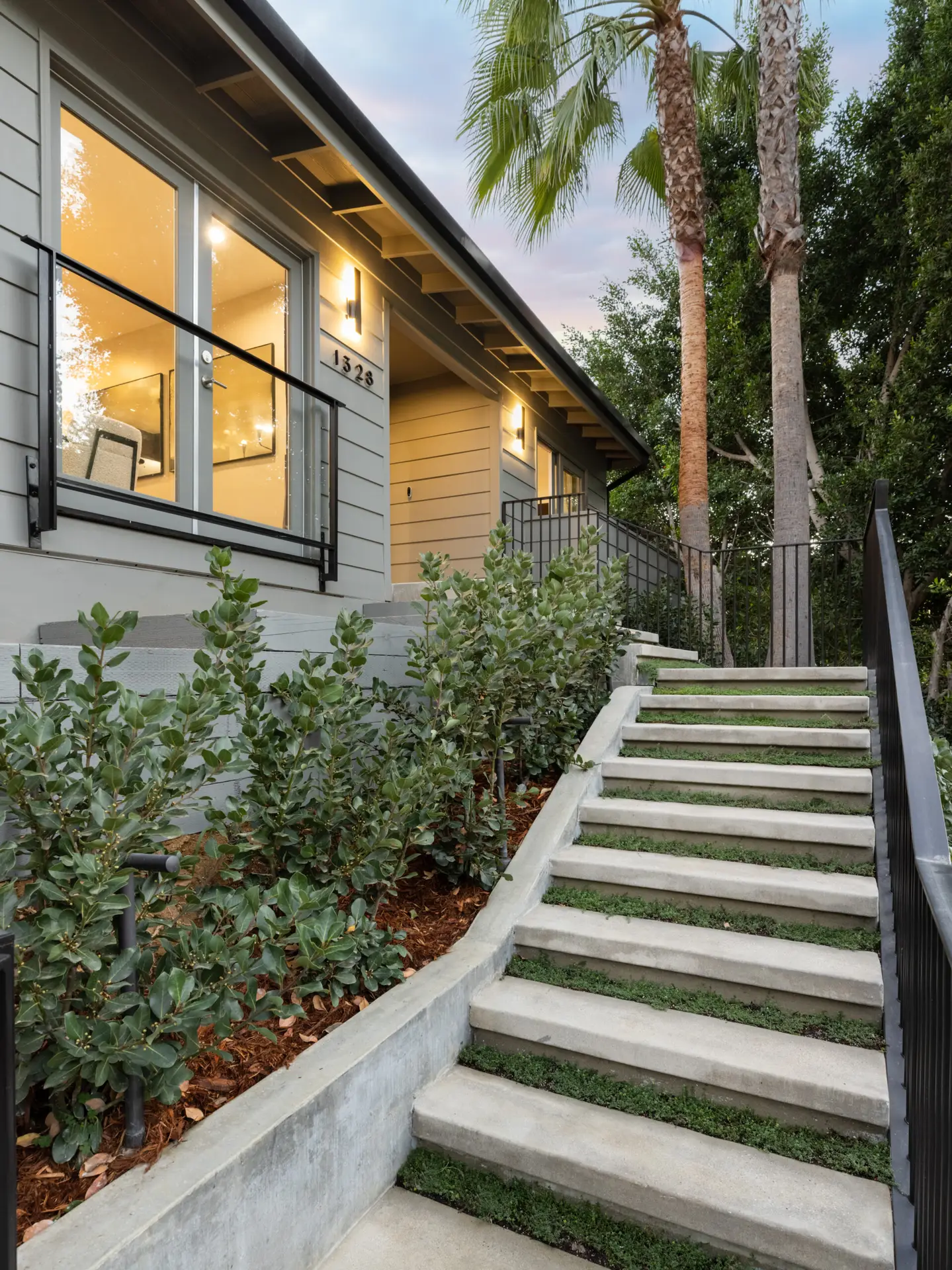 Highland Park Airbnb Management - Outdoor staircase leading to the entrance of Hollywood Hills Home with greenery and house view - Open Air Homes.
