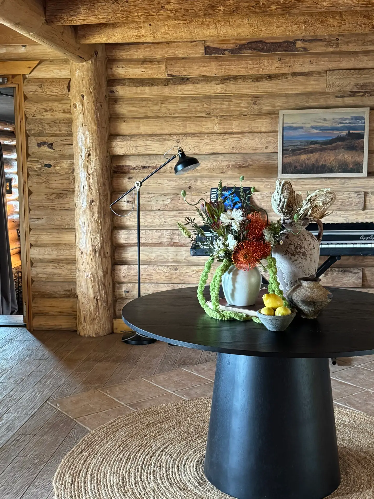 Rustic interior with a wooden table and vase of flowers in a cozy setting – Open Air Homes