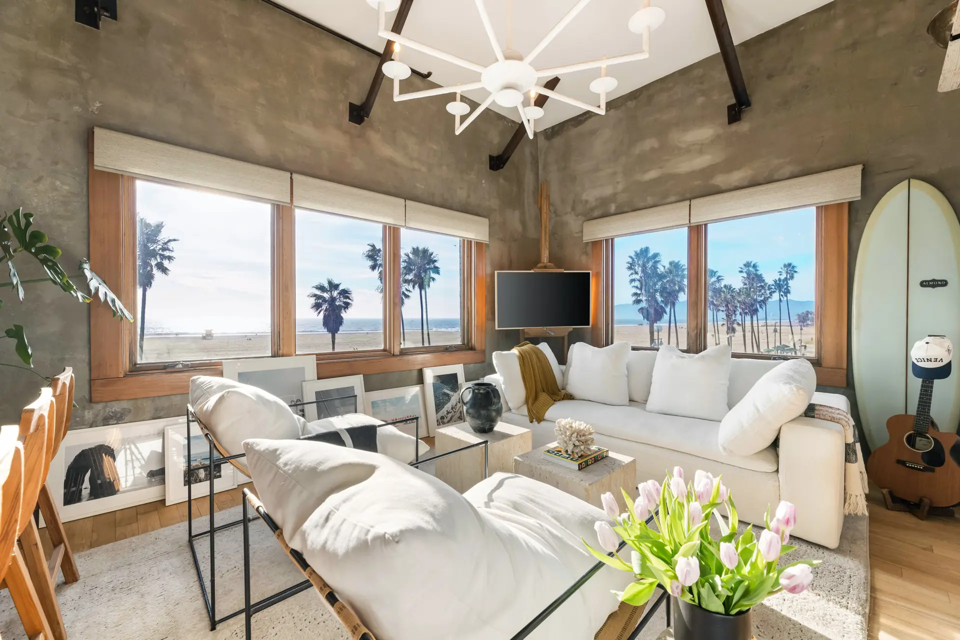 Venice Beach Rental Management - Living area with surfboard and beach view at Venice Beachfront Artist Loft – Open Air Homes
