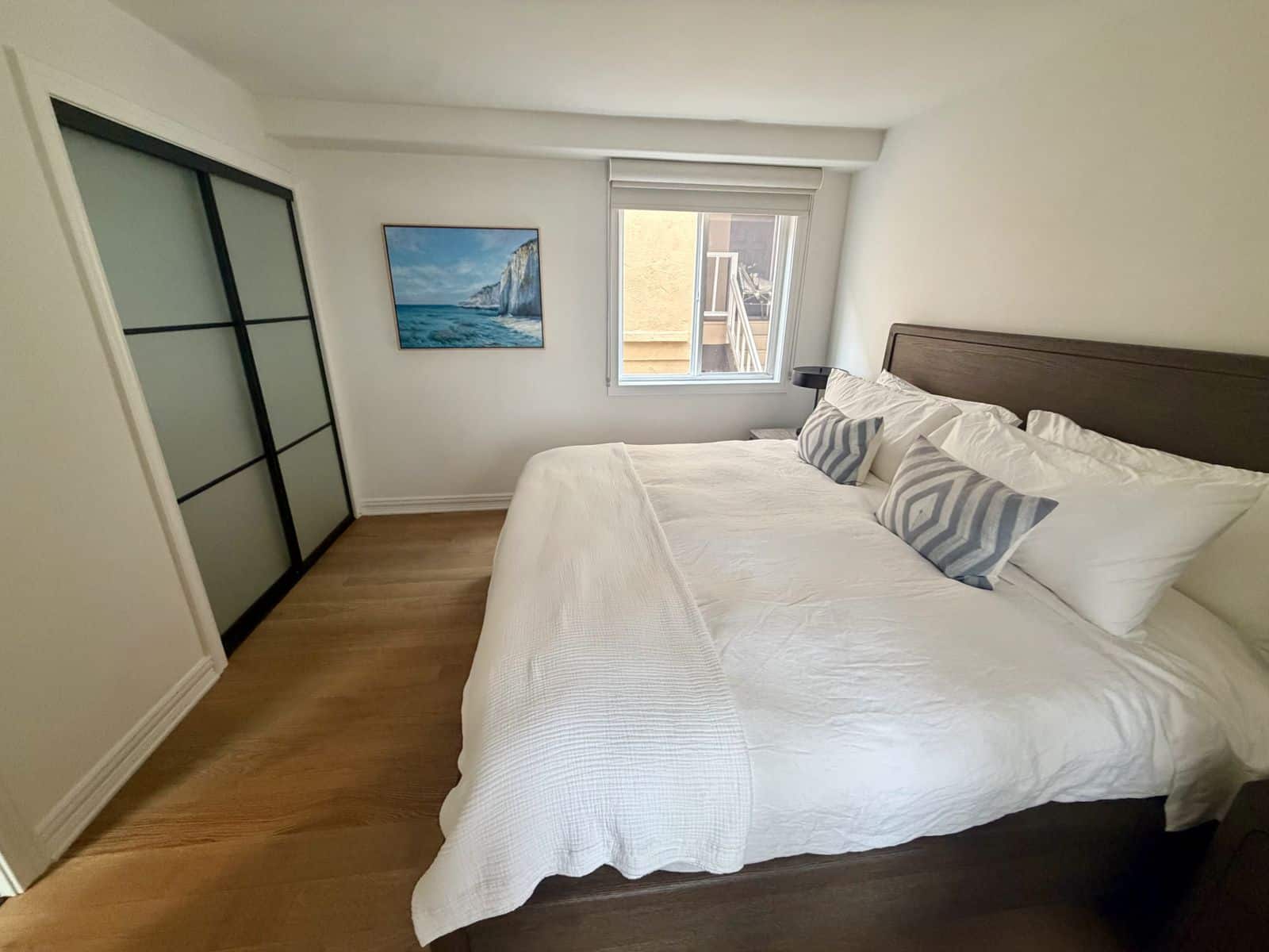 Second bedroom with closet, cliffs painting and a window onto the private balcony