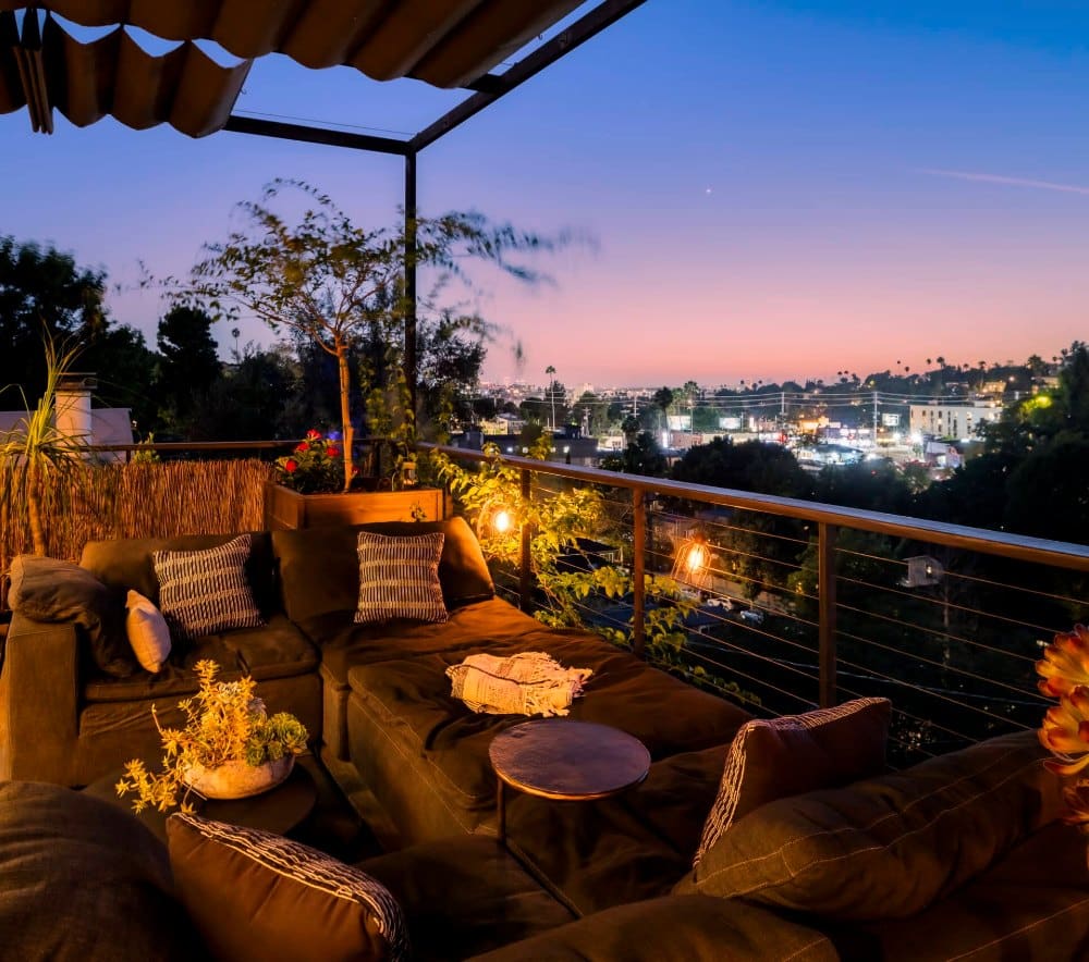 Deck lounge at dusk overlooking Silver Lake and the city lights, a Los Angeles home managed by Open Air Homes