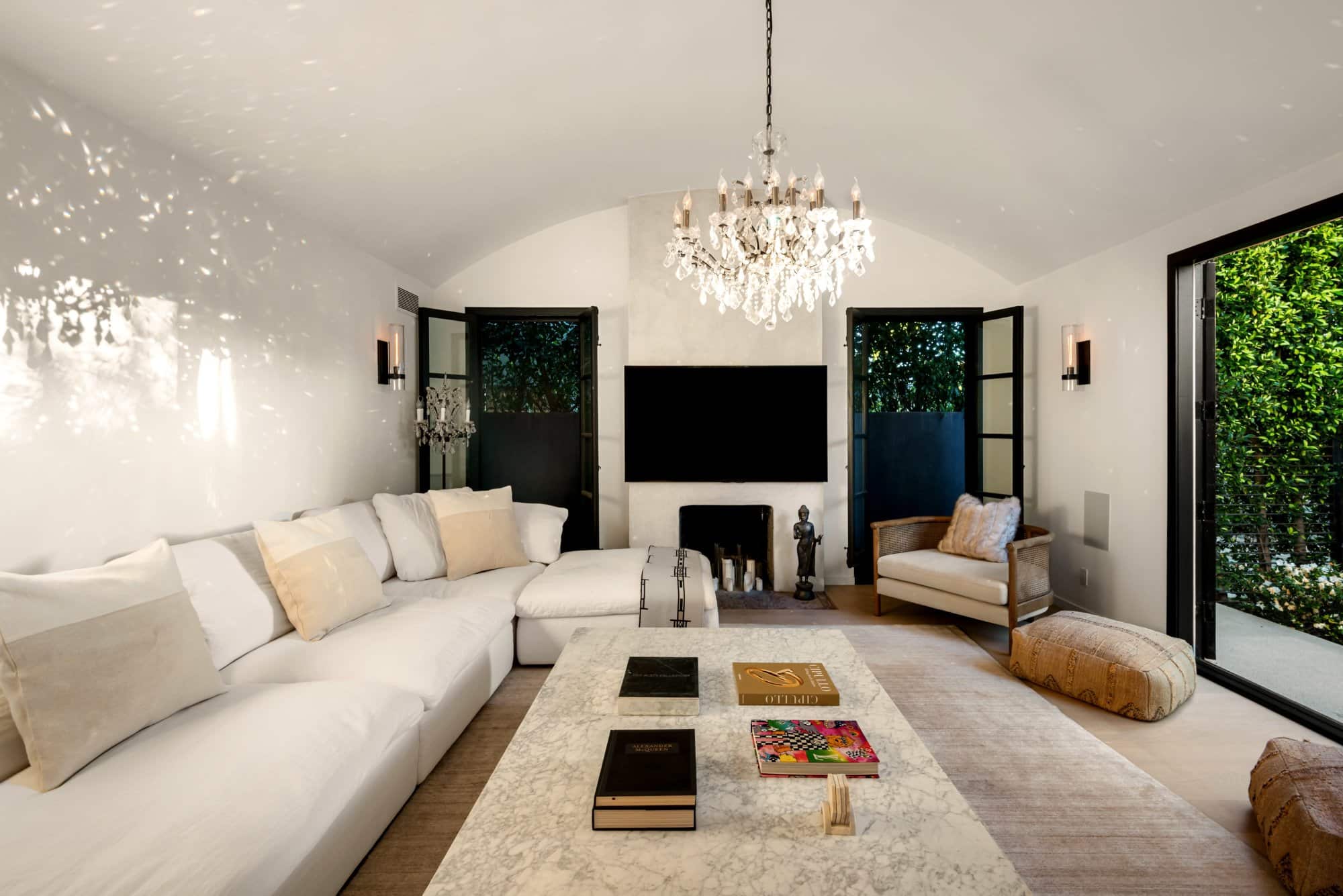 Bright living room with white sectional and crystal chandelier