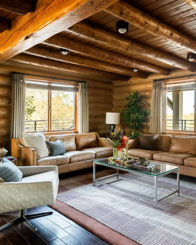 Spacious living room with wooden beams and leather sofas at Retreat to the Rocks, Ventura County