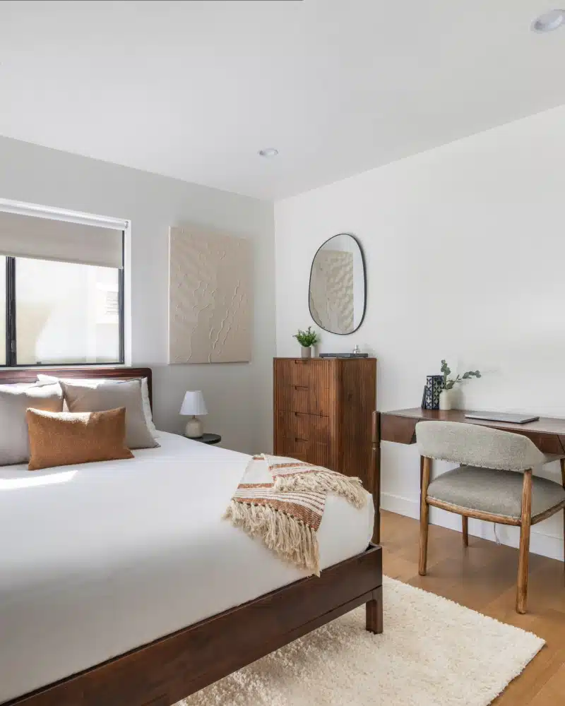 Echo Park Airbnb Management - Spacious bedroom with a large bed, desk, and plant in Pacific Ave short-term rental, Venice Beach.