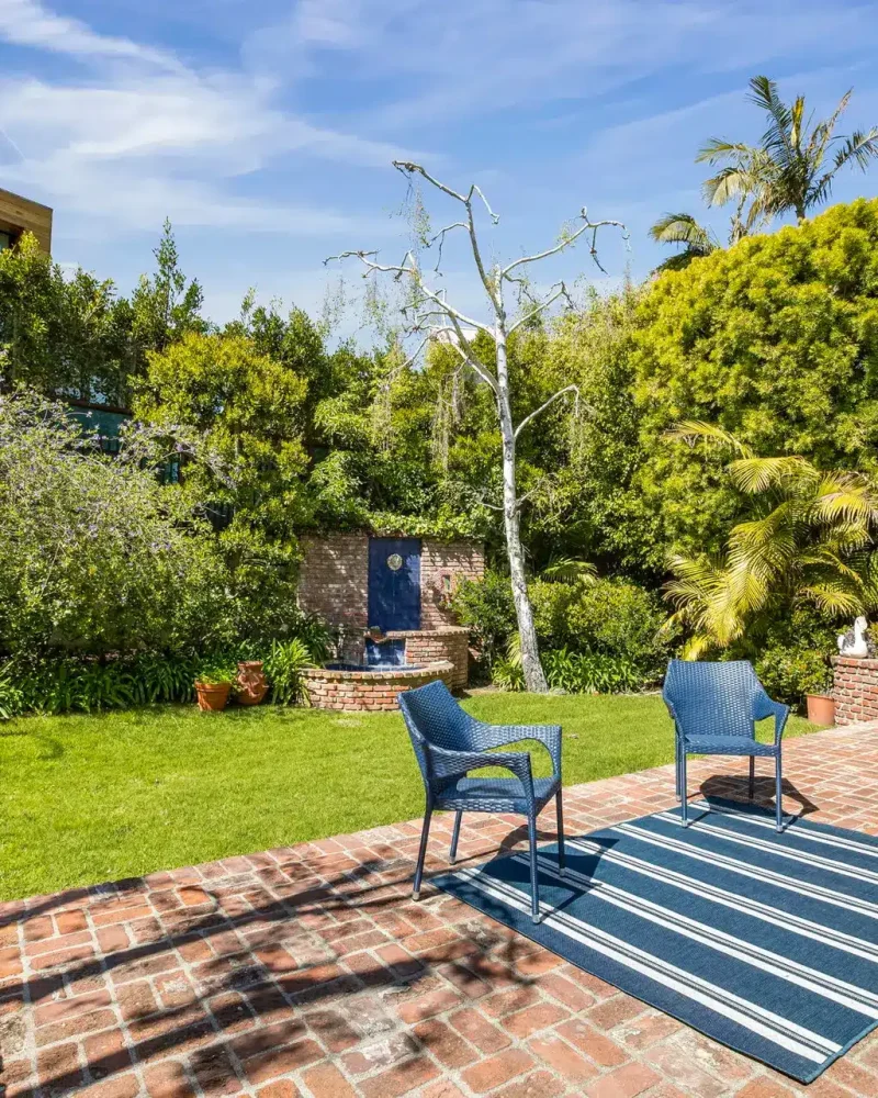 Patio with chairs and table in a garden setting in Pacific Palisades - Open Air Homes.