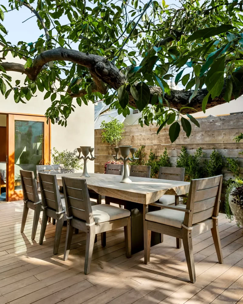 UnderstandinModern outdoor dining area on wooden deck with lush greenery - Open Air Homesg Airbnb and short-term rental regulations in Los Angeles.