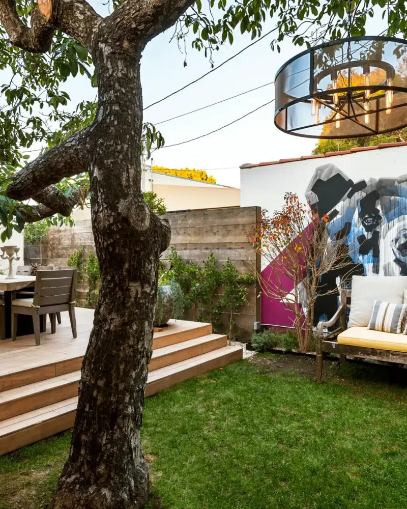 Westwood Airbnb Management - Beautifully landscaped backyard with seating area, fire pit, and tree providing shade - Open Air Homes
