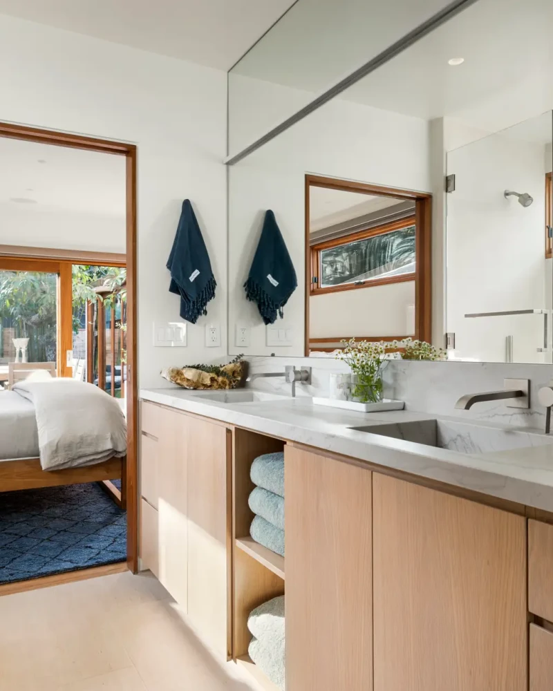 Westwood Airbnb Management - Modern bathroom with double sink, large mirror, and view into bedroom - Open Air Homes