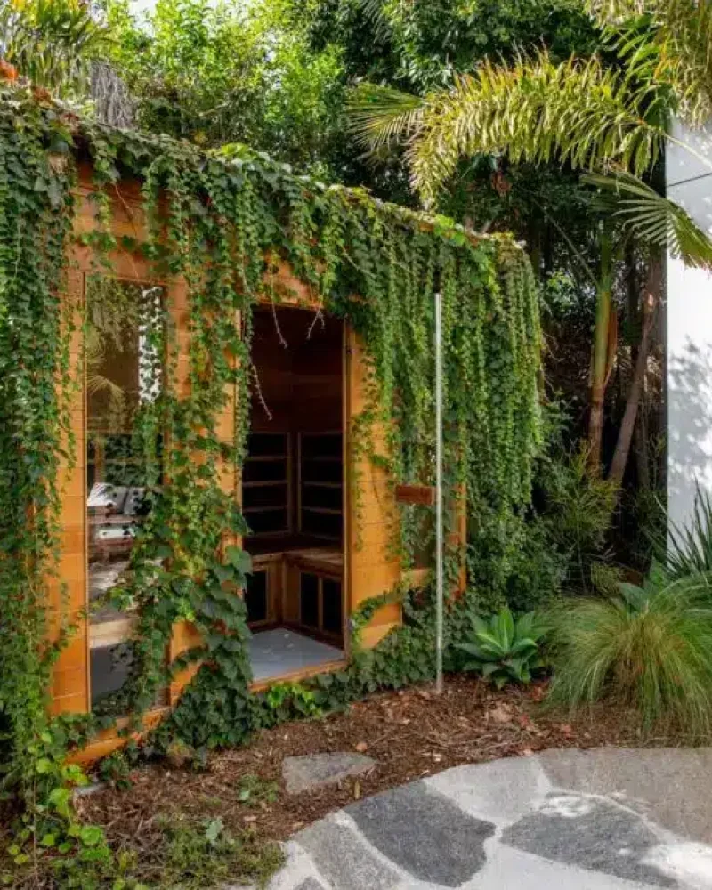 Outdoor sauna surrounded by greenery - by Open Air Homes.