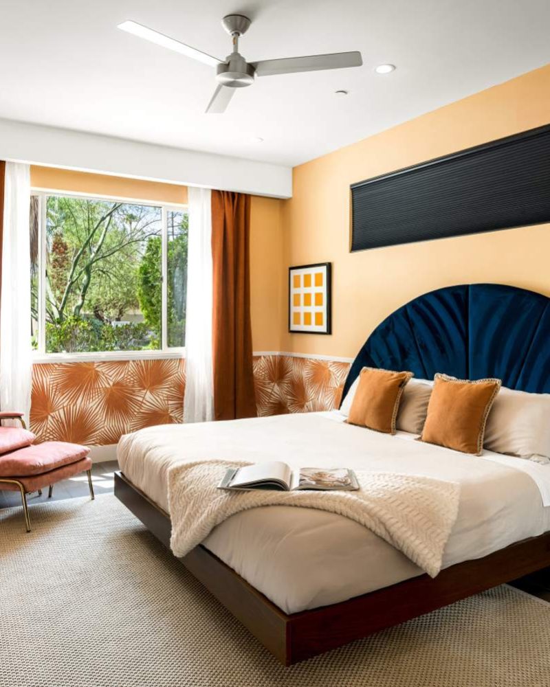 Primary bedroom with an arched headboard and windows to the garden
